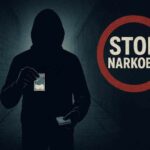IMG-20251018-WA0008 Ilustrasi sosok bertudung gelap membawa paket narkoba dengan tulisan "Stop Narkoba" di latar belakang.
