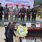 Peserta upacara dan Kapolres Morowali Utara melaksanakan prosesi tabur bunga peringatan Hari Pahlawan di Pelabuhan Kolonodale