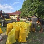 Personel Polsek Mori Atas menyiapkan karung jagung hasil panen petani binaan sebelum diserahkan ke Bulog Cabang Poso.