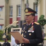 Seorang pejabat kepolisian membacakan amanat di podium pada upacara peringatan Hari Pahlawan di halaman Mapolda Sulteng.